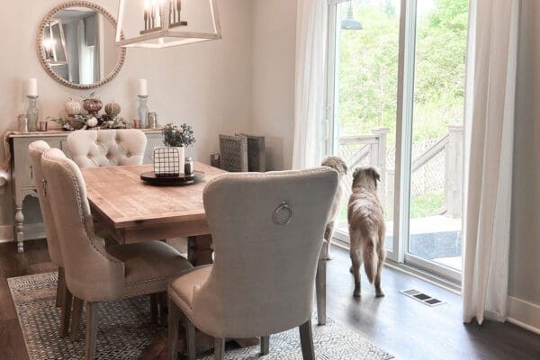 Dining area with large windows, modern chandelier, and open connection to the kitchen and living spaces.