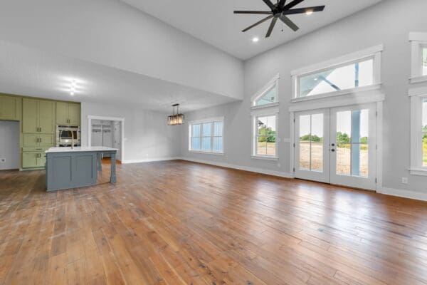 Spacious family room with large windows, vaulted ceiling, and luxury vinyl plank flooring.