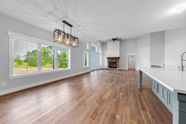 Bright dining room with large windows, hardwood flooring, and modern farmhouse lighting.