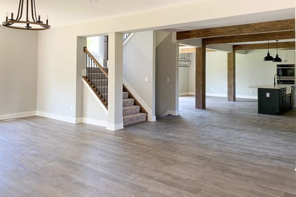 Bright foyer with staircase, luxury vinyl plank flooring, and open-concept view into the living areas.