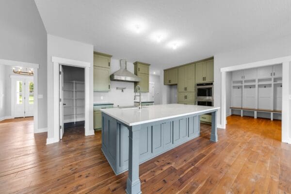 Open-concept kitchen with a blue center island, white cabinetry, and quartz countertops.