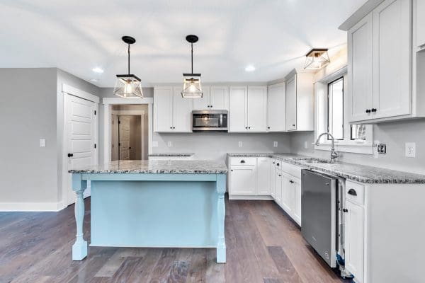 Spacious kitchen with a light blue island, white shaker cabinets, and an open-concept layout.