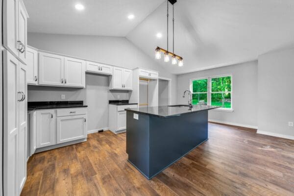 Custom kitchen with a blue center island, white cabinetry, quartz countertops, and pendant lighting.