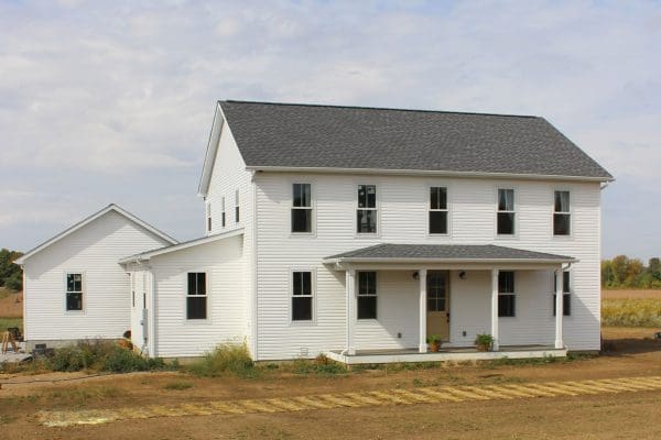 The Madison II with white siding and breezeway between home and garage.