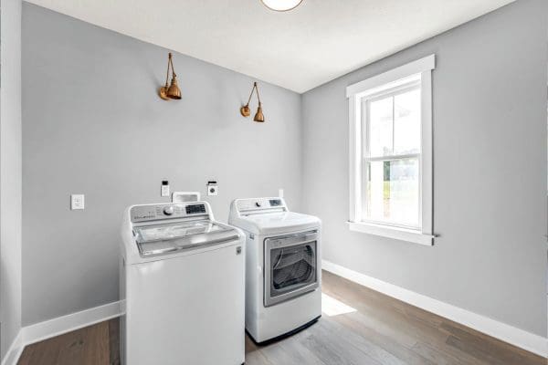 Laundry room with lvp flooring, farmhouse trim, and gray walls.