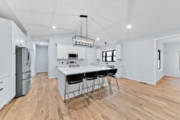 Spacious kitchen with a large island, white shaker cabinets, quartz countertops, and open-concept layout.