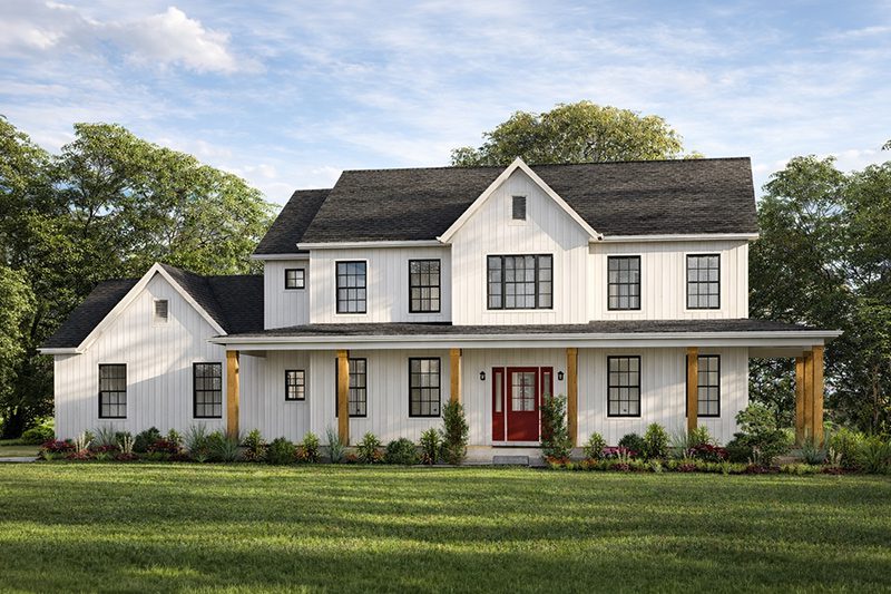 A main image daytime view of a large, two-story modern farmhouse with white vertical board-and-batten siding and a dark shingled, multi-gabled roof. The house features a wide, covered front porch supported by natural wood columns, a bright red double front door, and symmetrical black-framed windows. The home is surrounded by a green lawn, foundation landscaping with small bushes and red flowers, and mature green trees under a partly cloudy blue sky.
