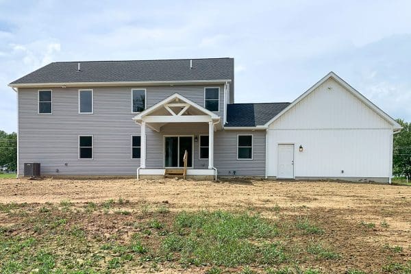 Rear exterior of the Madison II with gray siding and white board and batten on the garage and a covered porch.