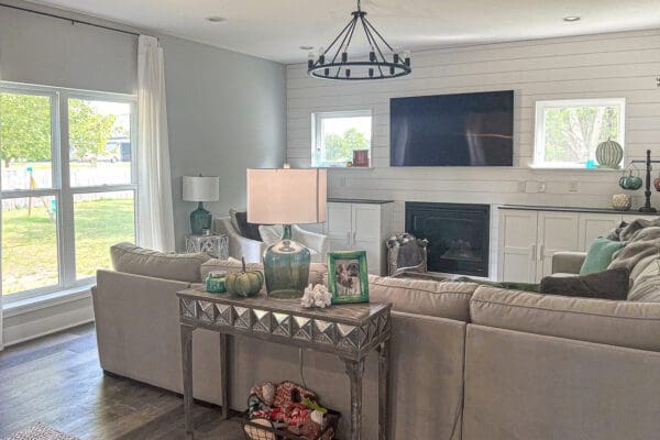 Open living room featuring a fireplace, modern lighting, and seamless flow into the dining and kitchen areas.
