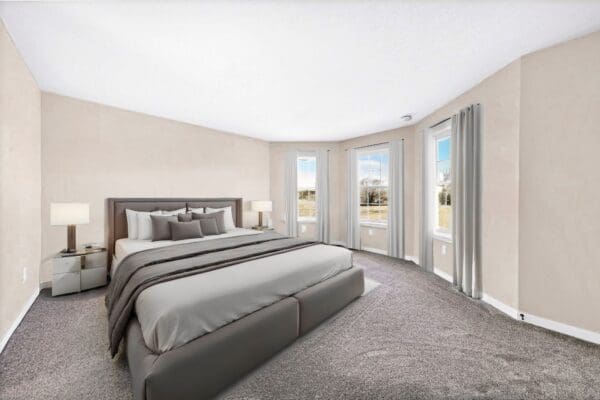 Spacious owner's suite with neutral carpeting, large windows overlooking the backyard, and plenty of room for a king-size bed and seating area.