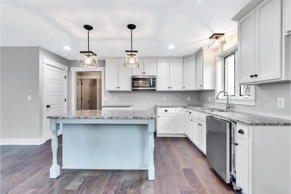 Kitchen in the newport floor plan with sea blue island and white perimeter cabinets.