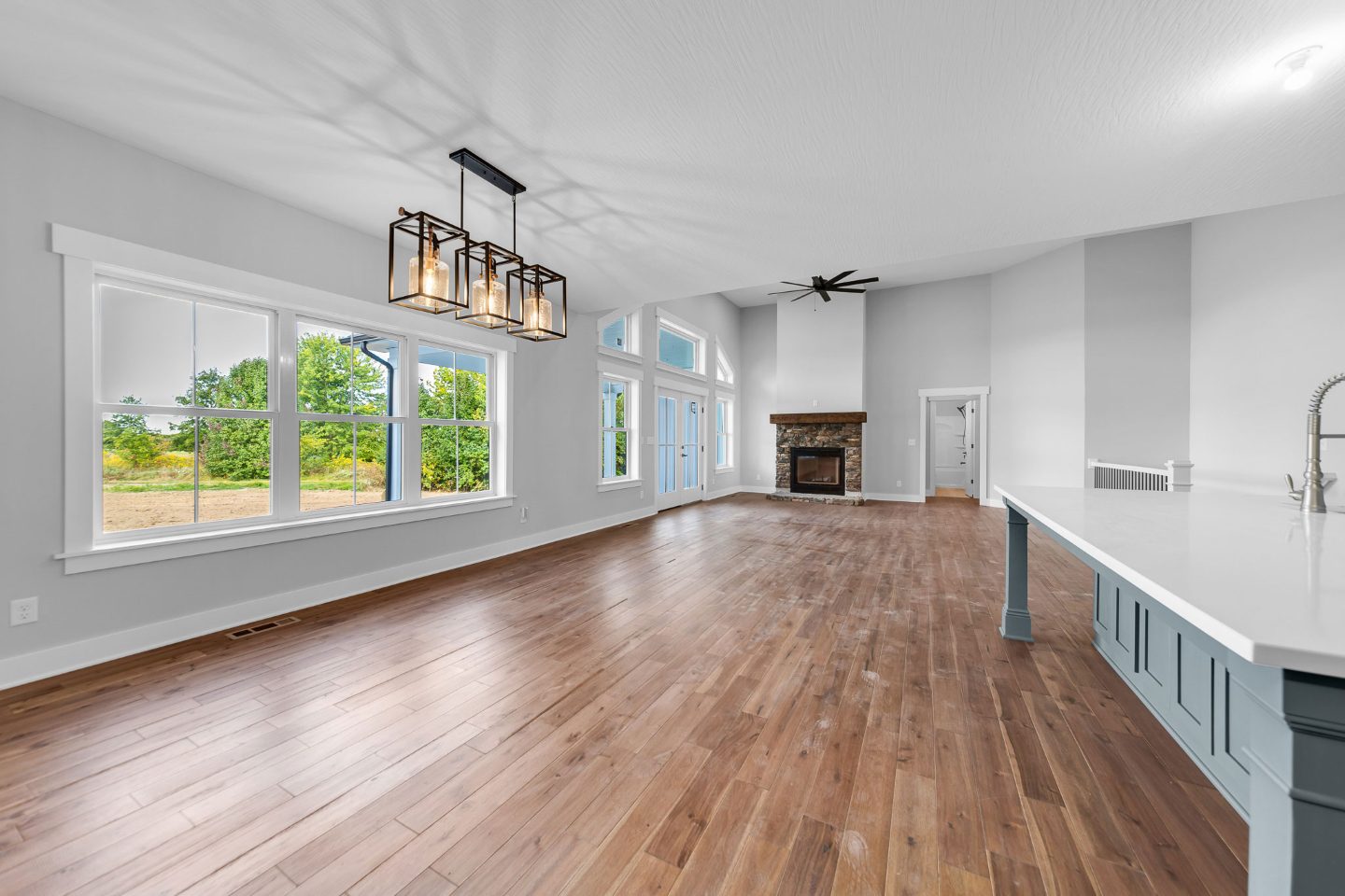 Open family room and dining with fireplace to ceiling.