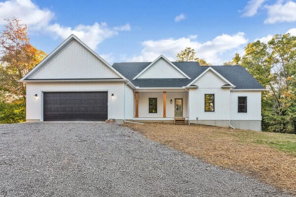 The Clark floor plan with white board and batten siding and gray shingles.