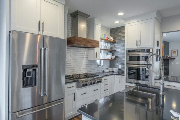 Custom kitchen with stainless appliances and custom backsplash.