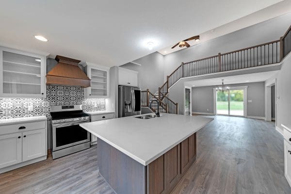 Custom kitchen with farmhouse backsplash, stained cabinets and white countertop.