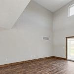 Two story family room of customized Walnut Creek design with wood flooring and sliding door.