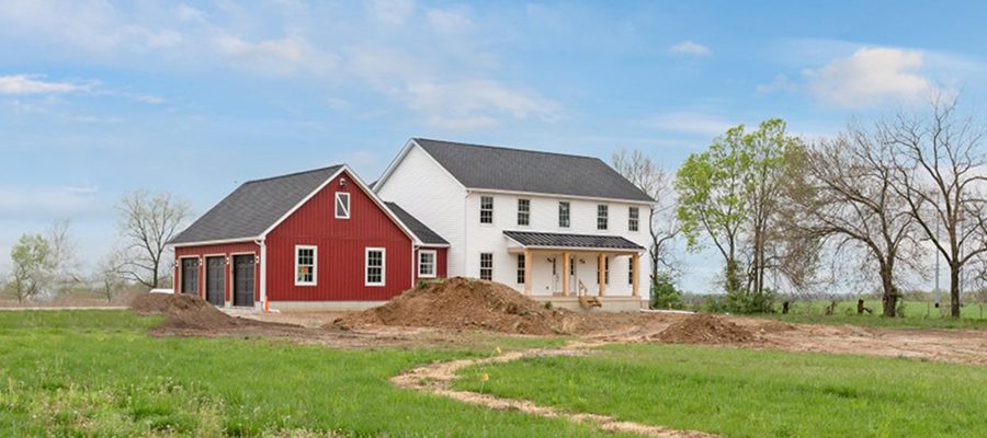 Madison II exterior with white vinyl horizontal siding and red board and batten on garage.