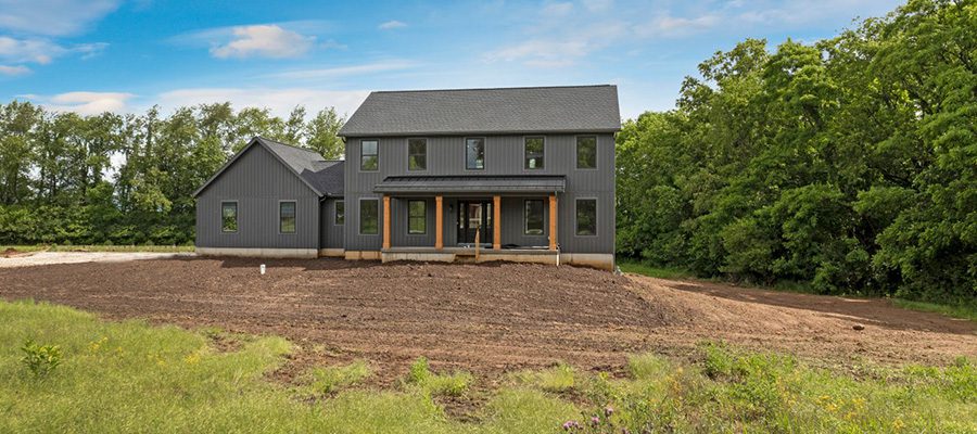 The Madison II with black windows, dark gray siding and large front porch.