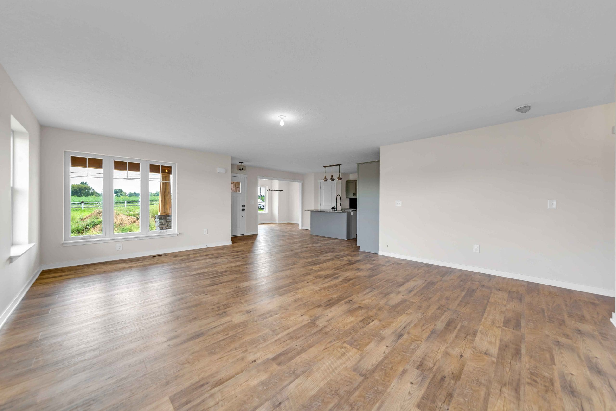 Open entry of the Barrington view toward kitchen and dining room with wood flooring, light taupe painted walls and white trim.
