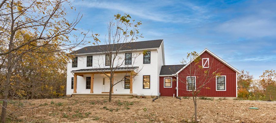 Madison II with black windows, white siding and red siding along garage.