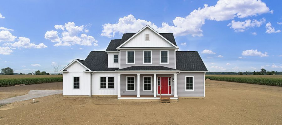 Blog image of the Danbury custom home with gray and white siding and a red front door.