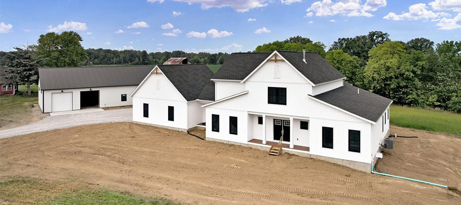 Drone exterior photo of the Carrollton with white board and batten siding, charcoal shingles and black windows.