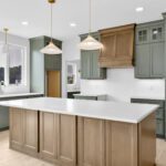 Large kitchen island with Smokey Brown stained maple cabinetry and light leathered countertops